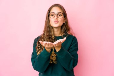 Beyaz kadın dudaklarını katlıyor ve hava öpücüğü vermek için avuçlarını tutuyor..