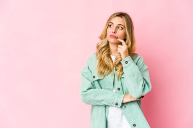 Kafkasyalı genç sarışın kadın şüpheli ve şüpheci bir ifadeyle yana bakıyor..