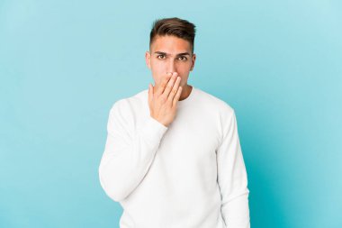 Beyaz tenli yakışıklı adam şok olmuş, ağzı ellerle kaplanmış, yeni bir şey keşfetmek için sabırsızlanıyor..