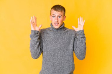 Genç, beyaz, yakışıklı bir adam zaferi ya da başarıyı kutluyor. Şaşırdı ve şok oldu..