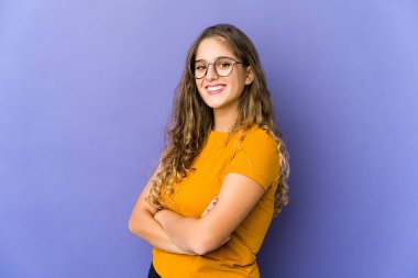 Genç, beyaz, kendine güveni tam bir beyaz kadın, kararlılıkla kollarını kavuşturuyor..