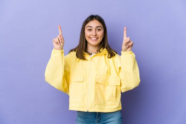 Kafkasyalı genç bir kadın, iki elini de havaya kaldırarak boş bir alan gösterdiğini gösteriyor..