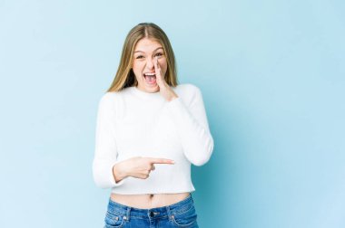 Mavi arka planda soyutlanmış genç sarışın bir kadın dedikodu yapıyor, bir şeyleri haber veriyor..