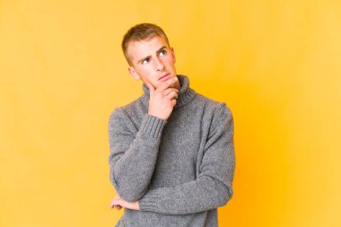 Kafkasyalı yakışıklı bir genç şüpheli ve şüpheci bir ifadeyle yana bakıyor..