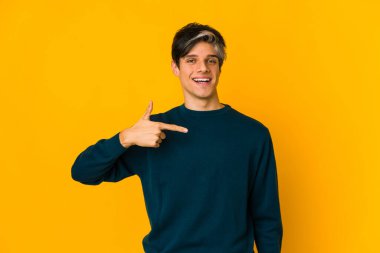 Genç, sıska, İspanyol bir adam tişörtün fotokopi odasını işaret ediyor.