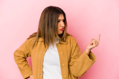 Pembe arka planda izole edilmiş genç Hintli kadın sanki seni davet ediyormuş gibi seni işaret ediyor..