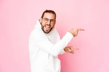 Uzun saçlı genç adam işaret parmağıyla işaret ettiği için heyecanlı görünüyor..