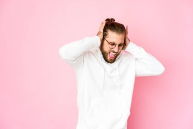 Uzun saçlı genç adam elleriyle kulaklarını kapatıyor..