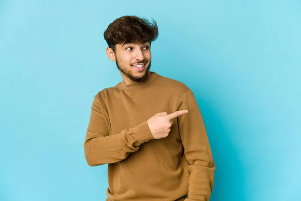 Ung Arabisk Man Blå Bakgrund Ser Sidan Leende Glad Och — Stockfoto