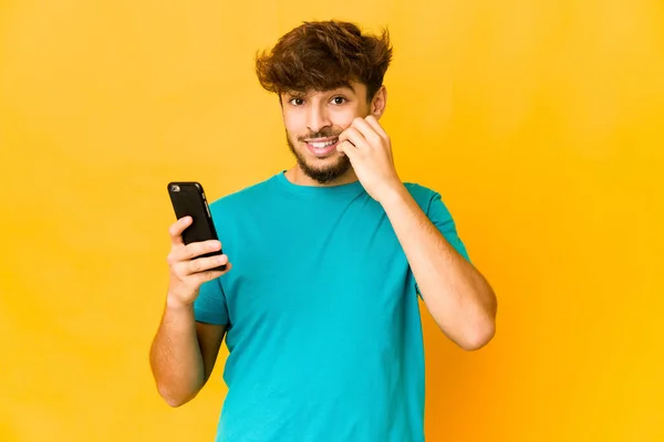 Joven Indio Sosteniendo Teléfono Mordiéndose Las Uñas Nervioso Muy Ansioso —  Fotos de Stock