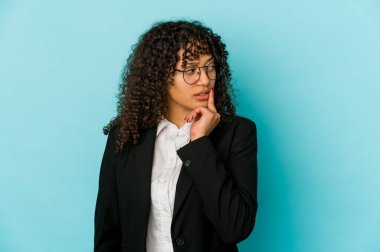 Genç Afro-Amerikan Afro kadın şüpheli ve şüpheci bir ifadeyle yanlamasına bakıyor..