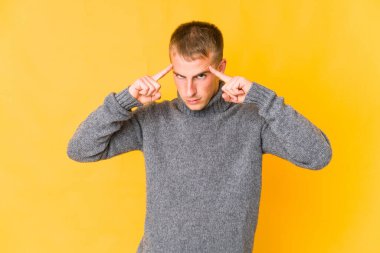 Kafkasyalı yakışıklı genç adam bir işe odaklanmış, işaret parmaklarını işaret ediyor..