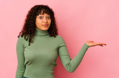 Genç Afrikalı Afro-Amerikan kadın, izole edilmiş, bir avuç içinde fotokopi alanı gösteriyor ve belinde bir el daha tutuyor..