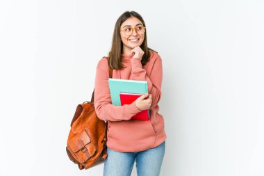 Beyaz fırında izole edilmiş genç bir kadın ellerini çenesinin altında tutuyor ve mutlu bir şekilde yan tarafa bakıyor..