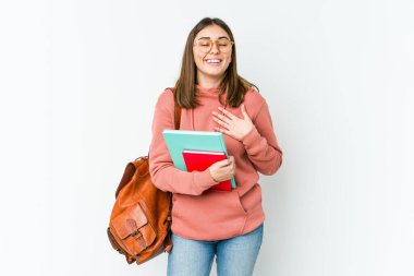 Beyaz fırında izole edilmiş genç bir kadın ellerini kalbe koyuyor, mutluluk kavramına gülüyor..