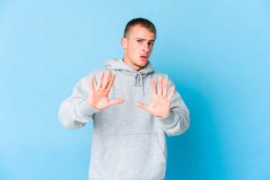 Beyaz tenli yakışıklı bir adam tiksinti ifadesi gösteren birini reddediyor..