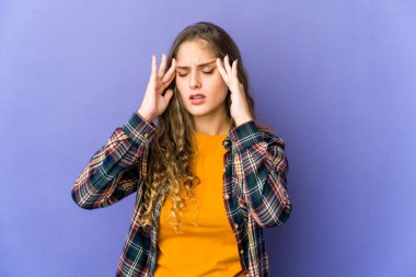 Genç beyaz kadın şakaklara dokunuyor ve baş ağrısı çekiyor..