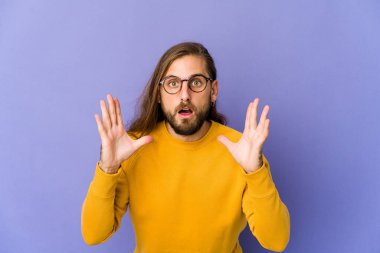 Uzun saçlı genç adam şaşırmış ve şok olmuş görünüyor..