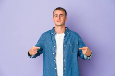 Beyaz tenli yakışıklı bir adam gömleğinin fotokopi odasını gösteriyor, gururlu ve kendinden emin.