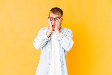 Beyaz tenli yakışıklı adam yüzünün yarısını palmiyeyle örterek eğleniyor..