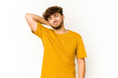 Beyaz arka plandaki genç Arap adam stresten dolayı boynu ağrıyor, masaj yapıyor ve elle dokunuyor..