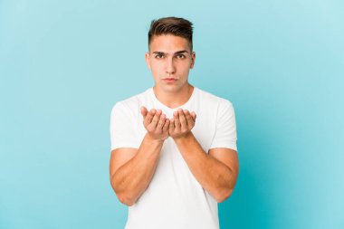 Beyaz tenli yakışıklı adam, dudaklarını katlayıp avuç içlerine hava öpücüğü yolluyor..