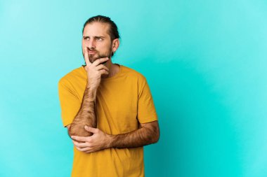 Uzun saçlı genç adam tefekkür ediyor, bir strateji planlıyor, iş yapmayı düşünüyor..