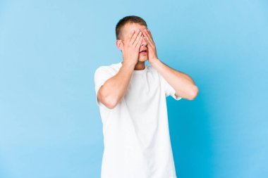 Beyaz tenli yakışıklı adam elleriyle gözlerini kapatmaktan korkuyor..