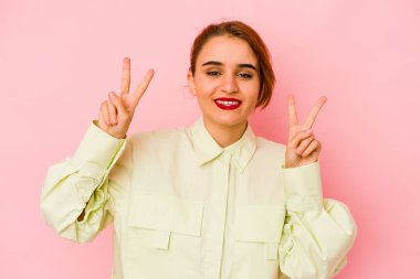 Genç Arap melez kadın zafer işareti gösteriyor ve gülümsüyor..