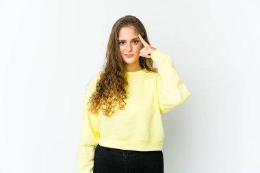 Kafkasyalı genç bir kadın şakağı parmağıyla işaret ediyor, düşünüyor, bir göreve odaklanıyor..