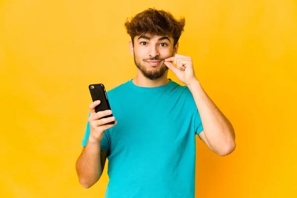 Joven Indio Sosteniendo Teléfono Con Los Dedos Los Labios Manteniendo —  Fotos de Stock