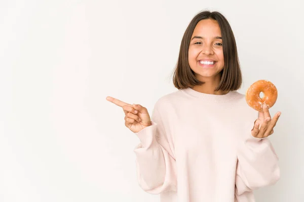 Young Hispanic Woman Eating Doughnut Smiling Pointing Aside Showing Something —  Fotos de Stock