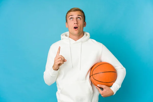 Młody Biały Człowiek Gra Koszykówkę Odizolowany Niebieskim Tle Wskazując Górę — Zdjęcie stockowe