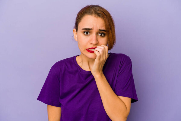 Young arab mixed race woman biting fingernails, nervous and very anxious.