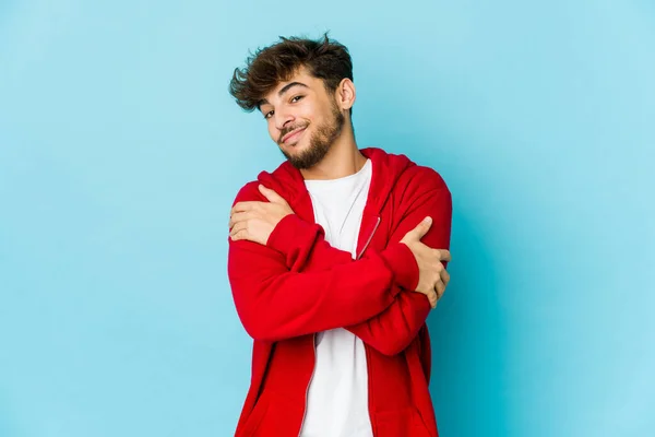 Hombre Árabe Joven Los Abrazos Fondo Azul Sonriente Despreocupado Feliz —  Fotos de Stock