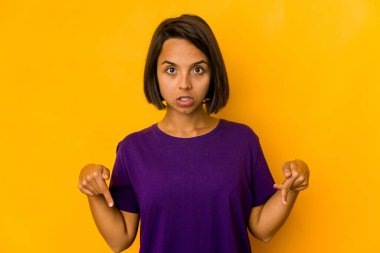 Genç İspanyol kadın, sarı noktalarda izole edilmiş parmaklarıyla, olumlu duygularla..