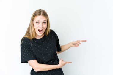 Beyaz arka planda izole edilmiş genç sarışın kadın işaret parmaklarıyla işaret ederek heyecanlanıyor..