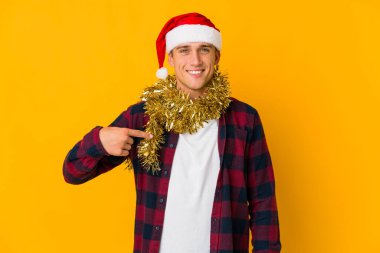 Sarı arka planda izole edilmiş, tırnak yiyen, gergin ve endişeli bir hediye taşıyan Kafkasyalı genç bir adam..