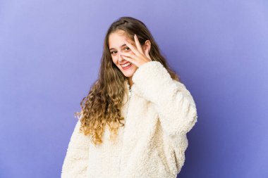 Beyaz tenli hoş bir kadın kameraya parmaklarıyla göz kırpıyor, utanarak yüzünü kapatıyor..