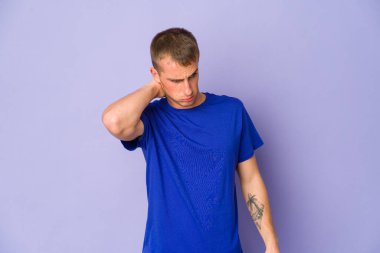 Genç, beyaz, yakışıklı bir adam stres yüzünden boynu ağrıyor. Masaj yapıyor ve eliyle dokunuyor..