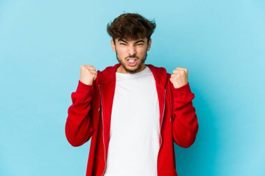 Mavi arka plandaki genç Arap gergin elleriyle çığlık atıyor..