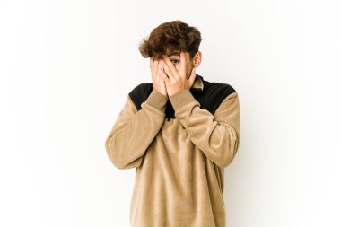 Beyaz arka planda genç bir Arap parmaklarıyla gözünü kırp korkmuş ve gergin..