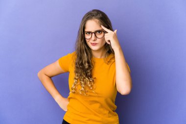 Genç, beyaz, sevimli bir kadın şakağı parmağıyla işaret ediyor. Düşünüyor, bir göreve odaklanıyor..