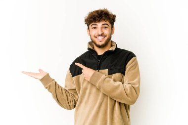 Beyaz arka planda genç bir Arap, elinde bir fotokopi odası tutarken heyecanlanıyor..