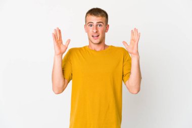 Genç, beyaz, yakışıklı bir adam zaferi ya da başarıyı kutluyor. Şaşırdı ve şok oldu..