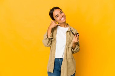 Elinde sigara piposu tutan genç İspanyol kadın cep telefonu hareketini parmaklarıyla gösteriyor..