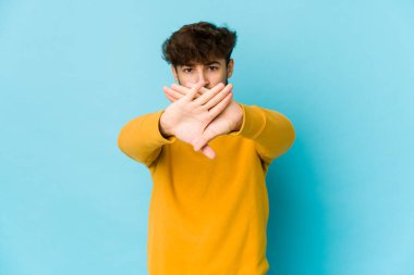 Mavi arka planda genç bir Arap inkâr jesti yapıyor.