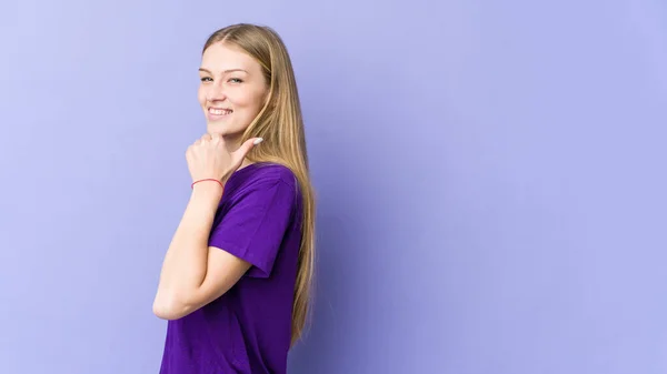 Young Blonde Woman Isolated Purple Background Points Thumb Finger Away — Stock Photo, Image