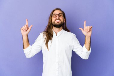 Uzun saçlı genç adam ön parmakları havada boş bir yer gösteriyor..