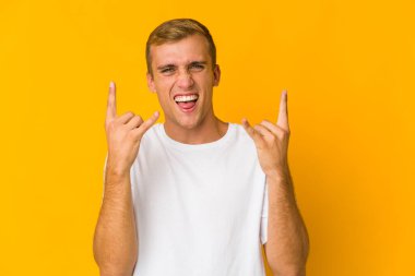 Genç beyaz yakışıklı adam boynuzlarını bir devrim konsepti olarak gösteriyor..